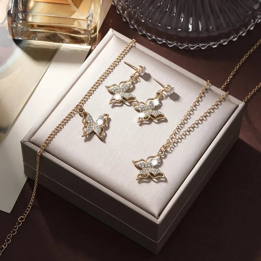 Ensemble bijoux trois pièces :  boucles d'oreilles papillon, collier avec pendentif, bracelet,